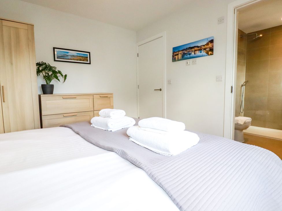 A bedroom with a bed and towels at Lavender House in Crantock