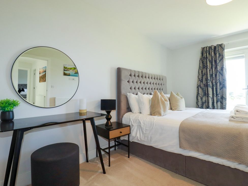 A bedroom with a bed and mirror at Lavender House in Crantock