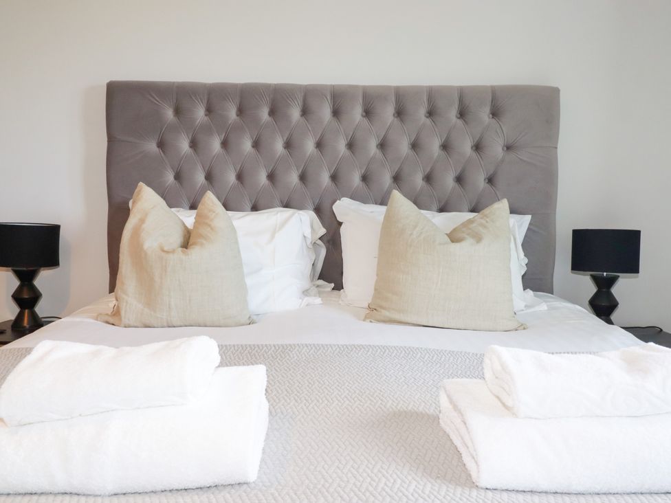 A bedroom with a bed, pillows, and lamps at Lavender House in Crantock
