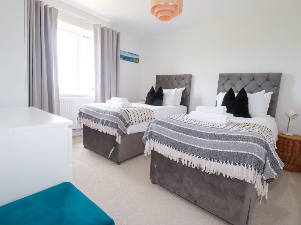 A bedroom with twin beds and a window at Lavender House Crantock