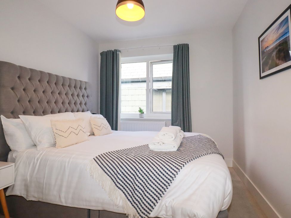 A bedroom with a bed and a window at Lavender House in Crantock