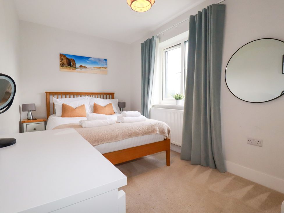 A bedroom with a bed and side table at Lavender House in Crantock