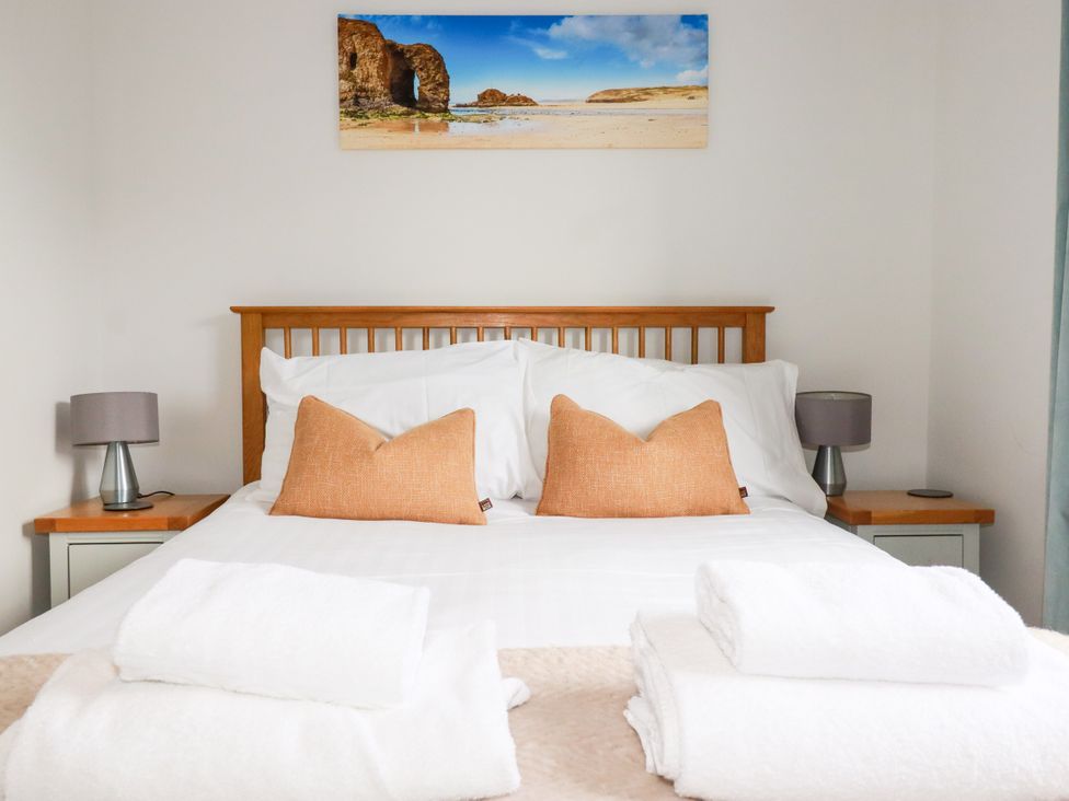 A bedroom with a bed and lamps at Lavender House in Crantock