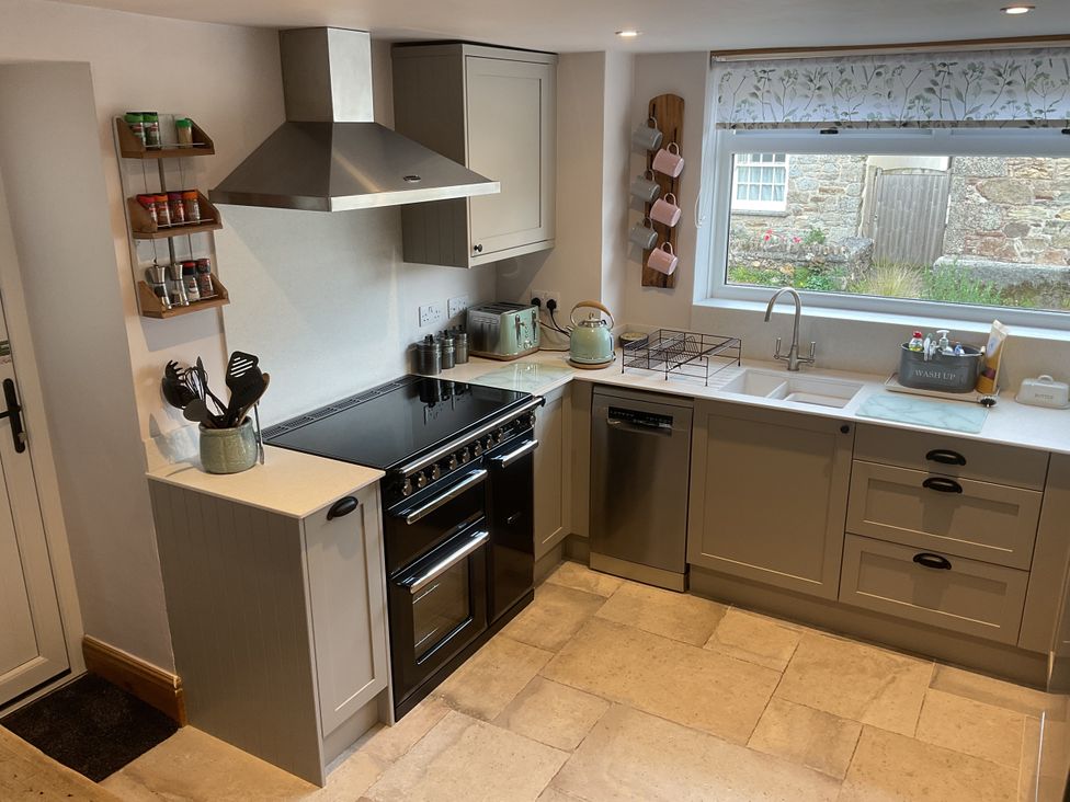 A kitchen with stove, sink and cupboard at Woodbine Cottage, Mylor Bridge, Nr Falmouth