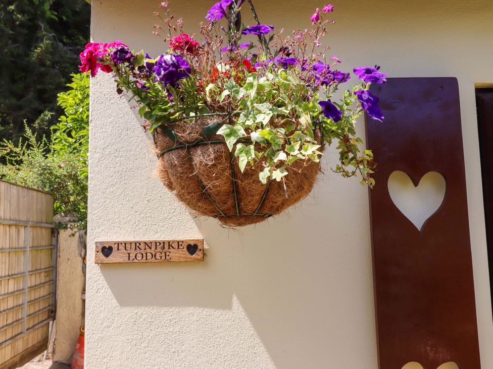 A flower basket and sign at Turnpike Lodge in Brixham