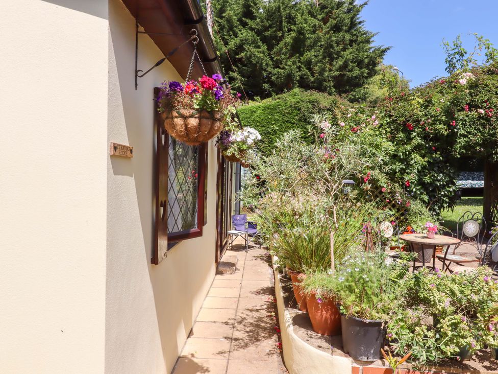 A garden with potted plants and a table at Turnpike Lodge in Brixham