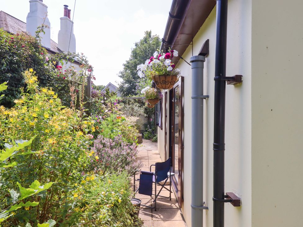 A garden with flowers and a chair at Turnpike Lodge in Brixham