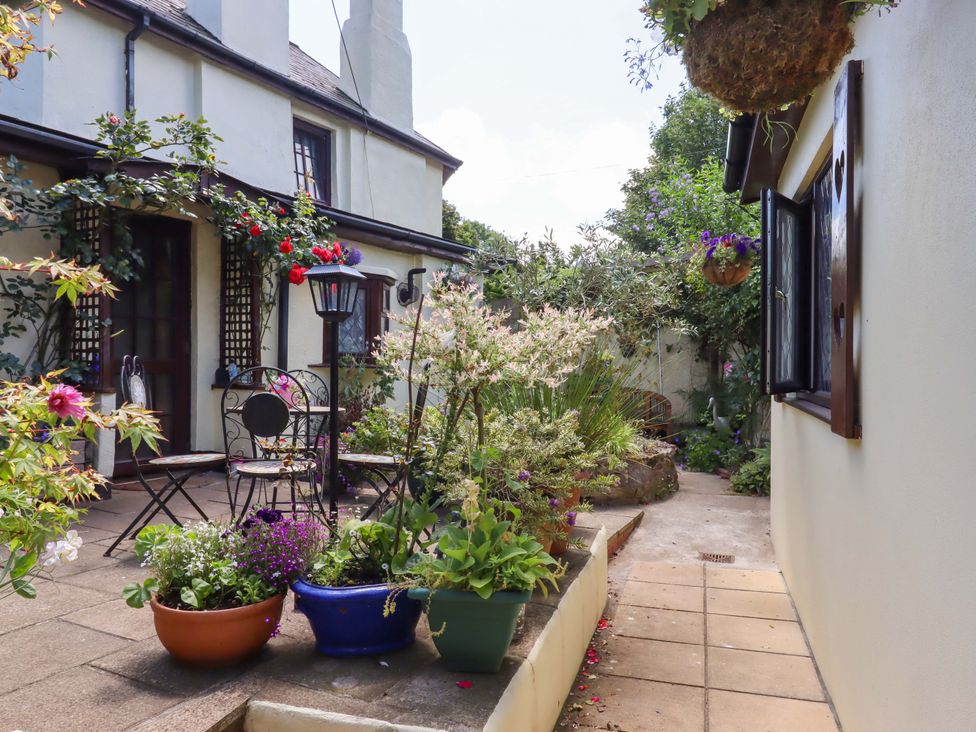 A garden with potted plants and chairs at Turnpike Lodge in Brixham