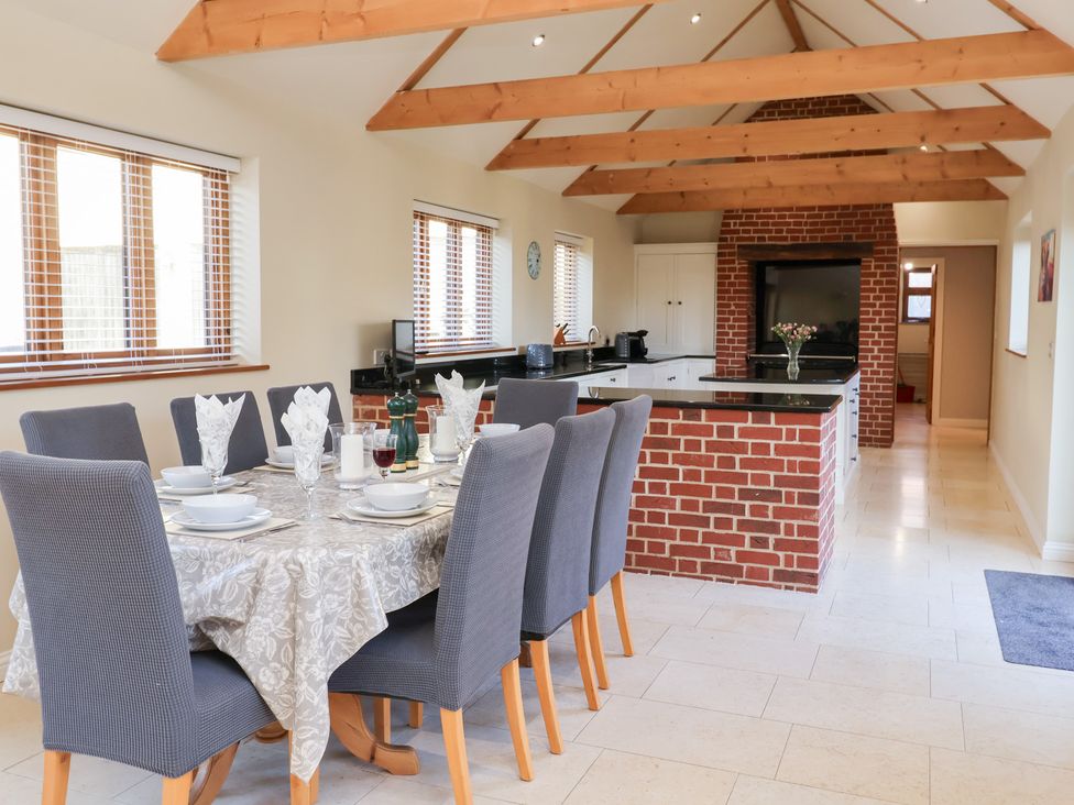 A kitchen with a dining area and a breakfast bar at The Stables at Hall Barn Wattisfield near Walsham-Le-Willows