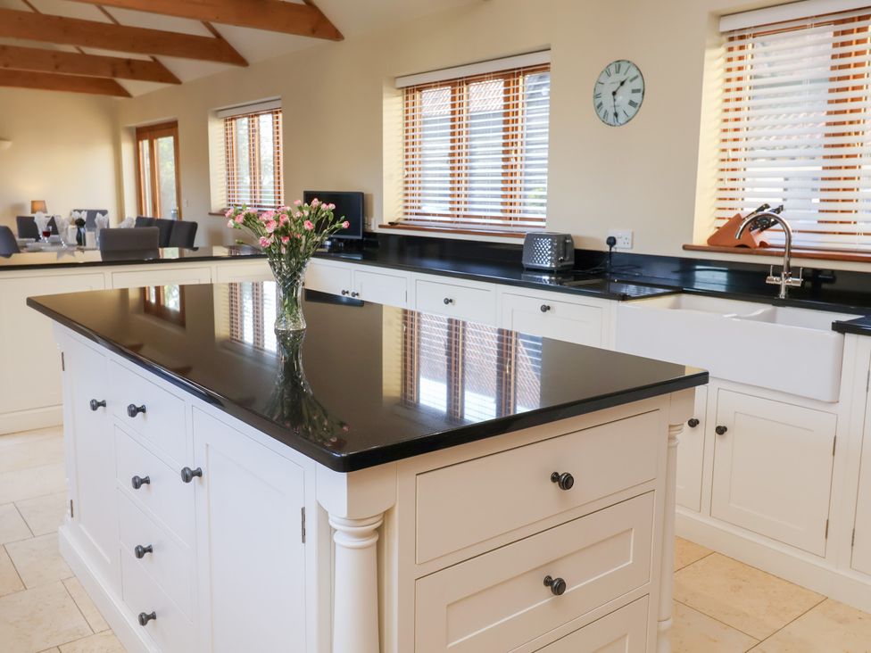 A kitchen with an island and sink at The Stables at Hall Barn Wattisfield near Walsham-Le-Willows