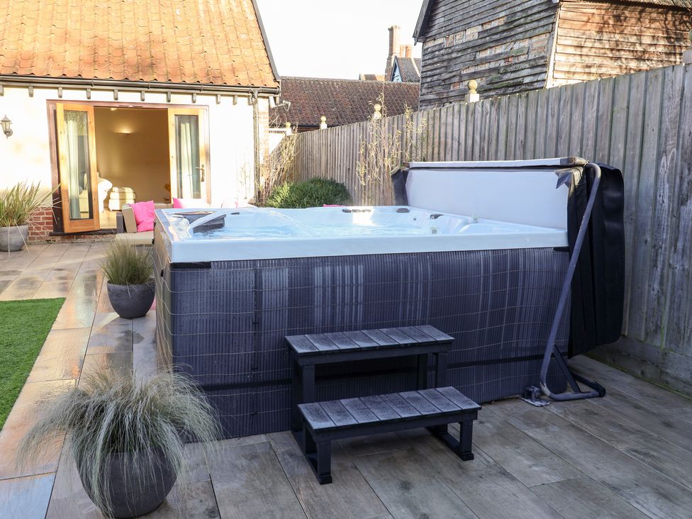 A garden with a hot tub and outdoor step at The Stables at Hall Barn Wattisfield near Walsham-Le-Willows