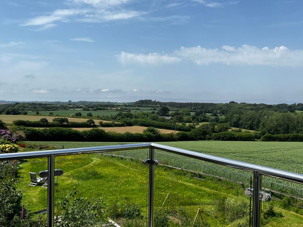 A balcony view overlooking fields and hills at Spires Playing Place near Carnon Downs
