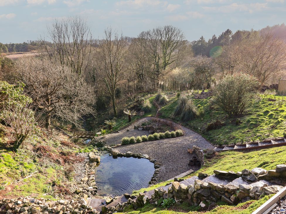 A garden with a pond and plants at Birchenhayes St Dominick