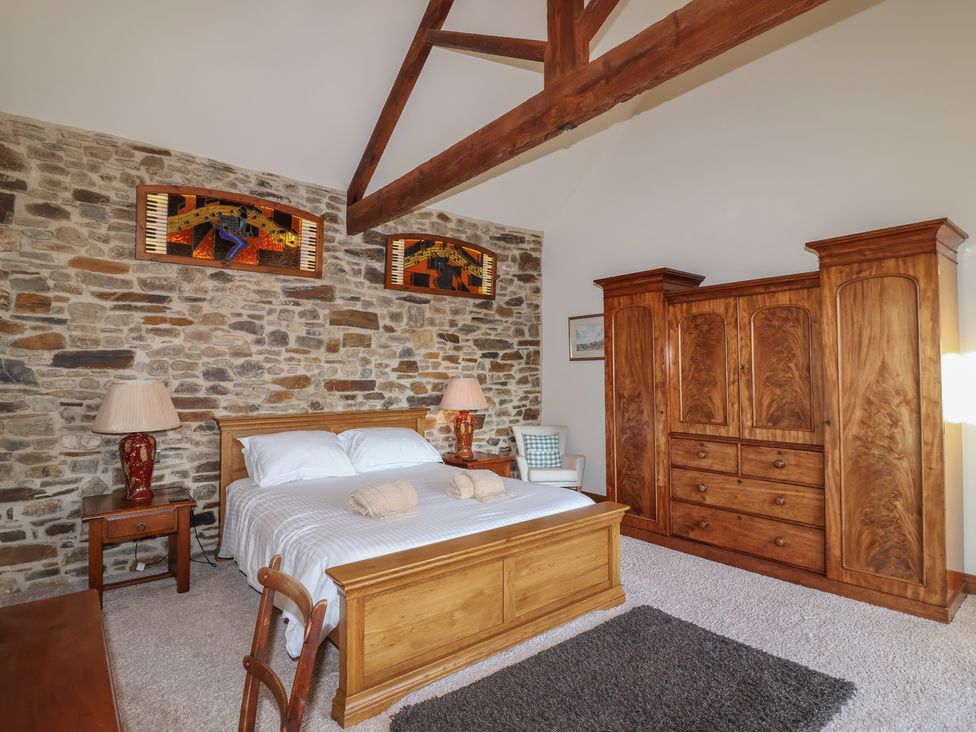 A bedroom with a bed and wardrobe at Birchenhayes St Dominick