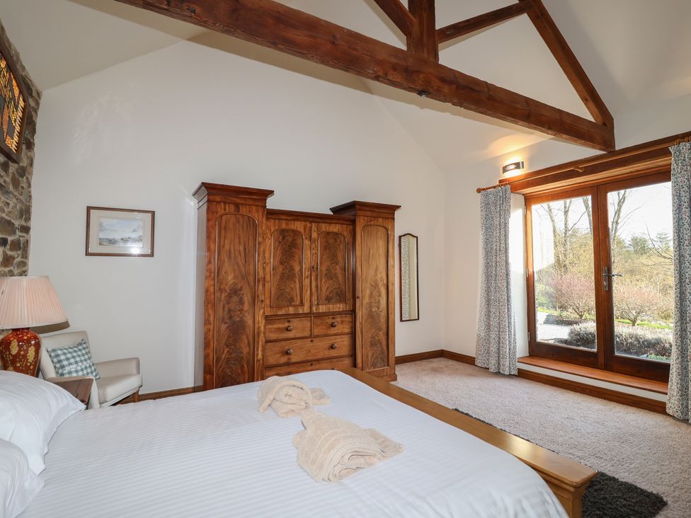 A bedroom with a bed and wardrobe at Birchenhayes in St Dominick