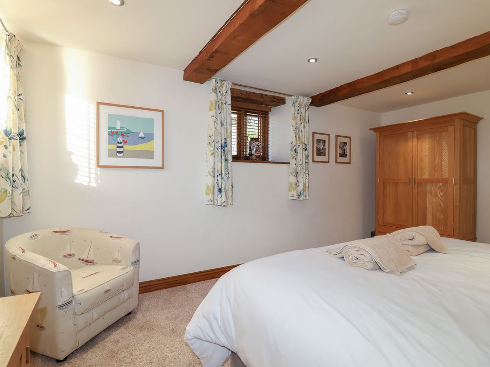 A bedroom with a bed and wardrobe at Birchenhayes St Dominick