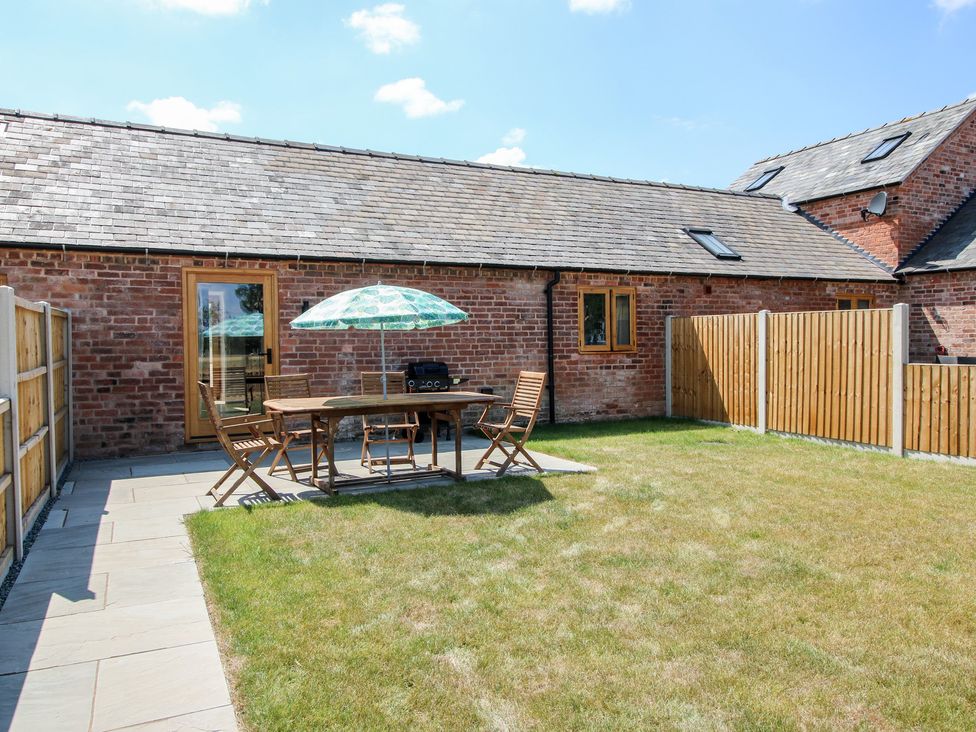 A garden with a table and chairs at Oak Barn 
