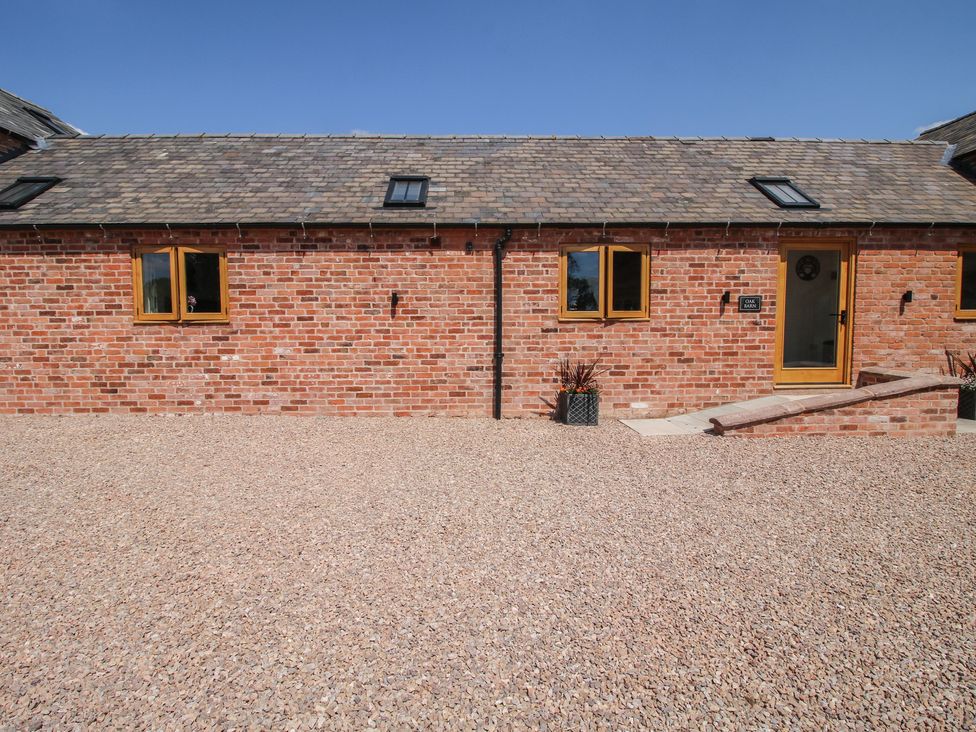 A brick exterior with windows and a door at Oak Barn