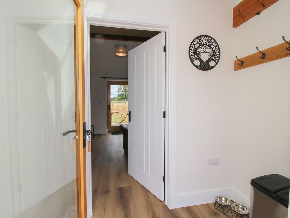 A hallway with a door and hooks on the wall at Oak Barn Northwood near Wem