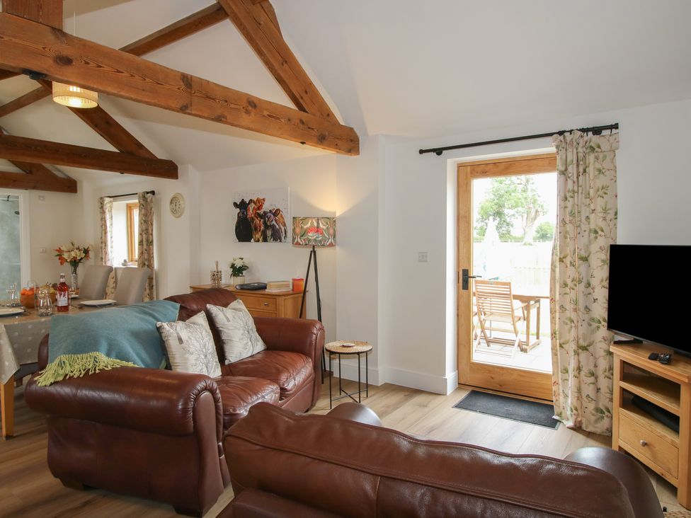 A living room with door leading outside at Oak Barn near Wem