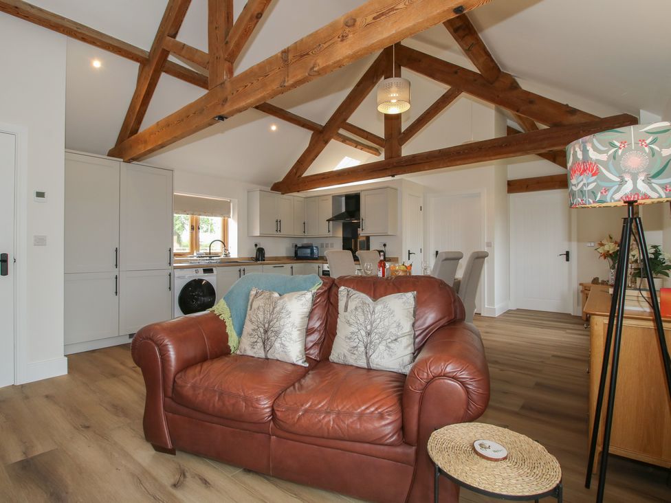 A living room with a sofa and kitchen units at Oak Barn in Northwood near Wem