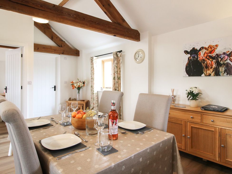 A dining room with a table set for a meal at Oak Barn Northwood near Wem