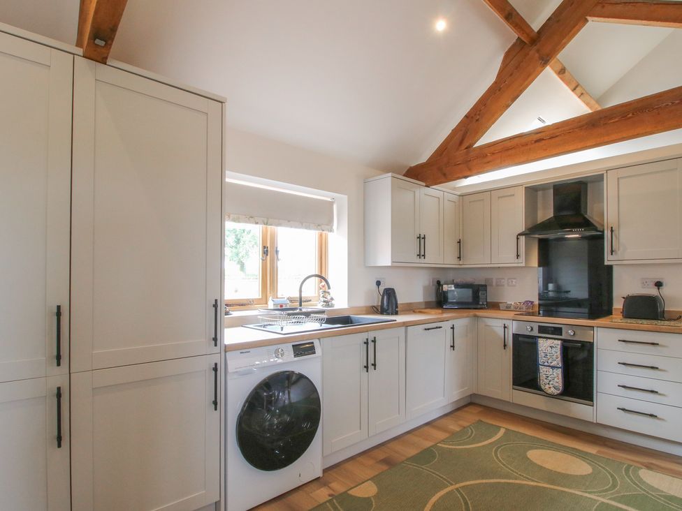 A kitchen with appliances and wooden beams at Oak Barn Northwood near Wem