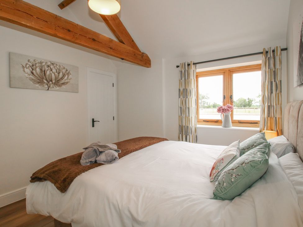 A bedroom with a bed and windows at Oak Barn Northwood near Wem