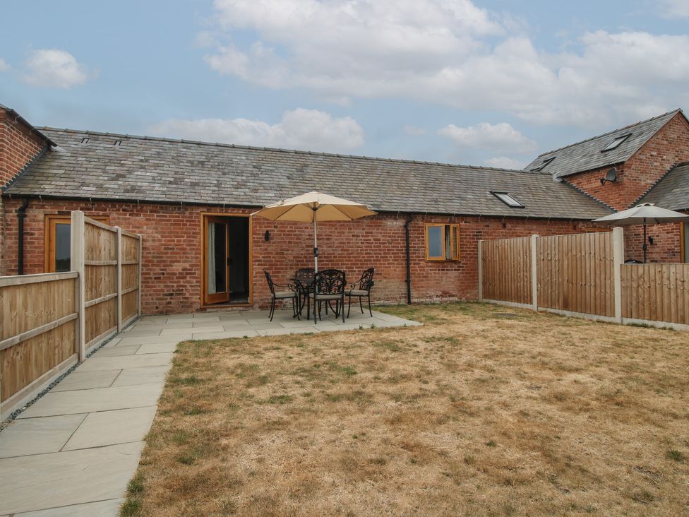 A garden with a table and chairs under an umbrella at Oak Barn near Wem
