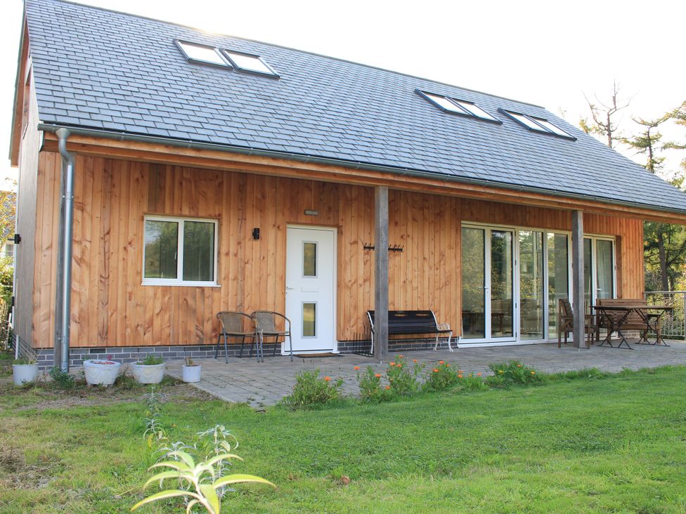A house with patio furniture and garden at Narracott Down South Molton
