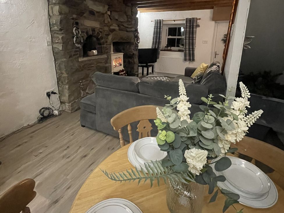 A living room with a fireplace and a sofa at Old Chapel House in Llanfairfechan