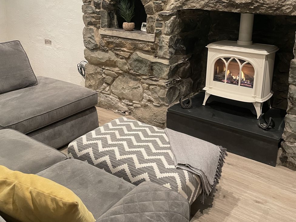 A living room with a sofa and fireplace at Old Chapel House in Llanfairfechan