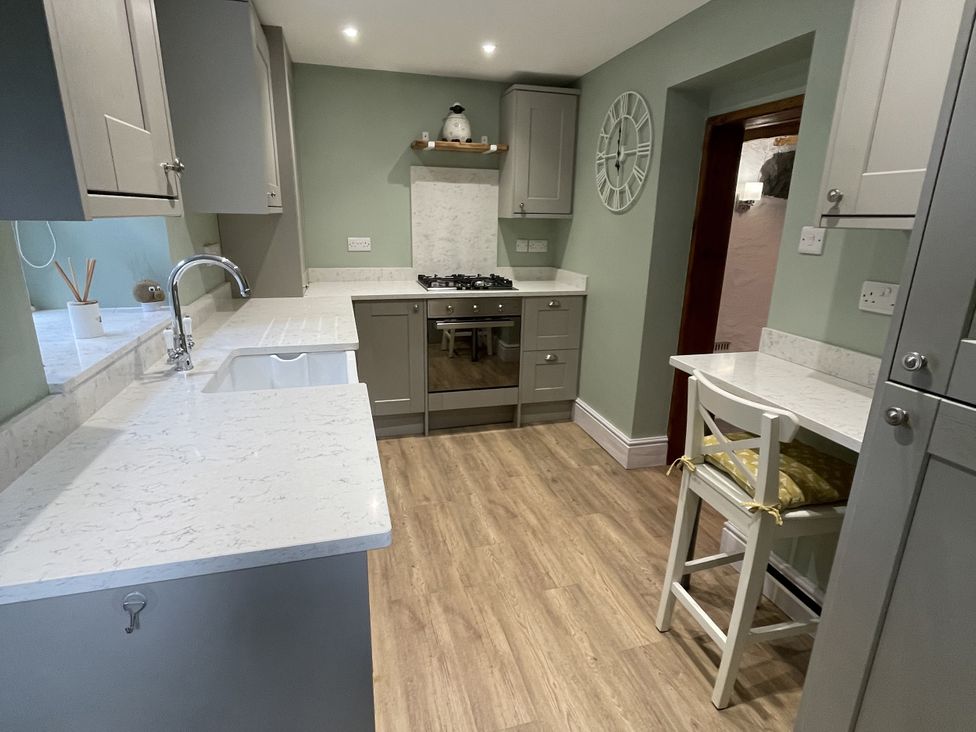 A kitchen with cabinets and a stove at Old Chapel House Llanfairfechan
