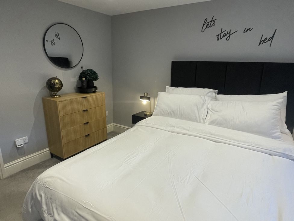 A bedroom with a bed and a dresser at Old Chapel House in Llanfairfechan