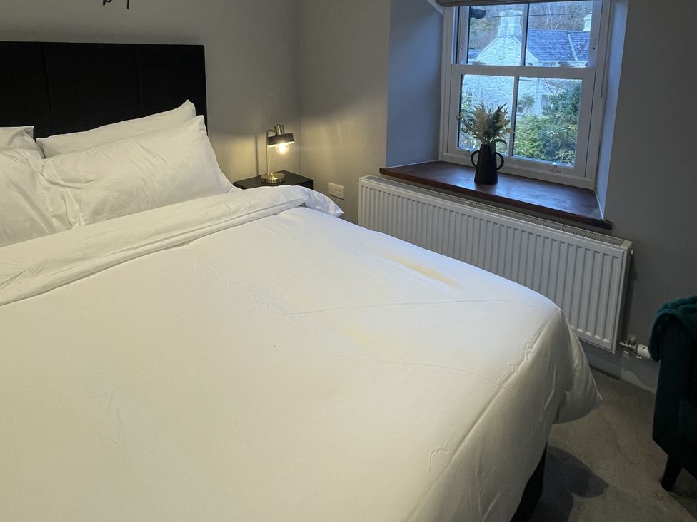 A bedroom with a bed and lamp at Old Chapel House Llanfairfechan