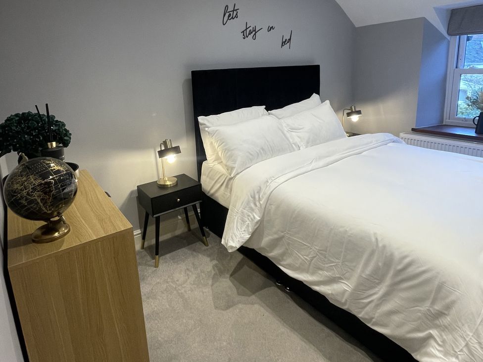 A bedroom with a bed and nightstand at Old Chapel House Llanfairfechan