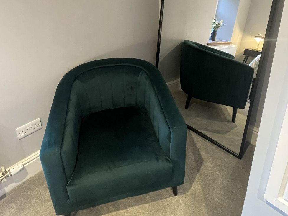 A chair and a mirror in a bedroom at Old Chapel House Llanfairfechan