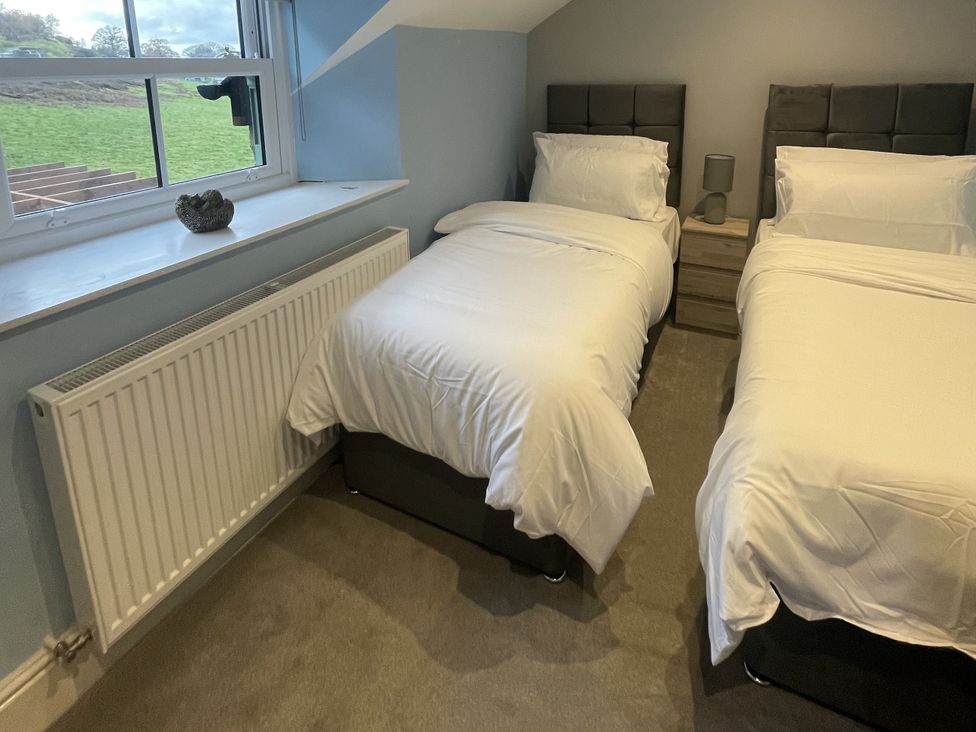 A bedroom with two beds and a window at Old Chapel House Llanfairfechan