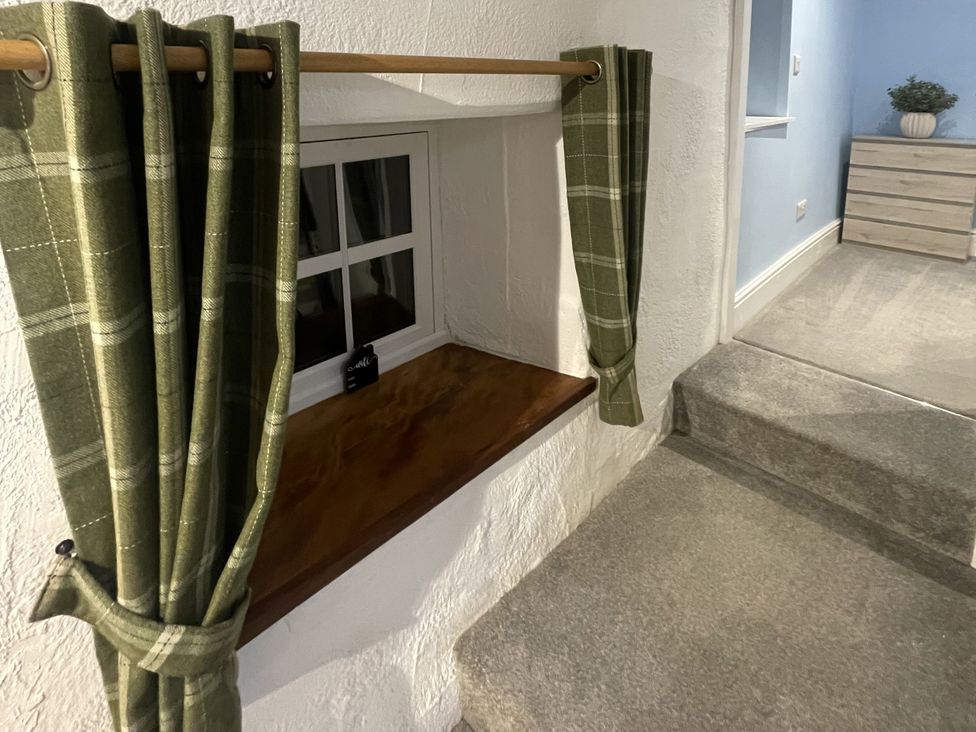 A window with curtains and a staircase at Old Chapel House Llanfairfechan