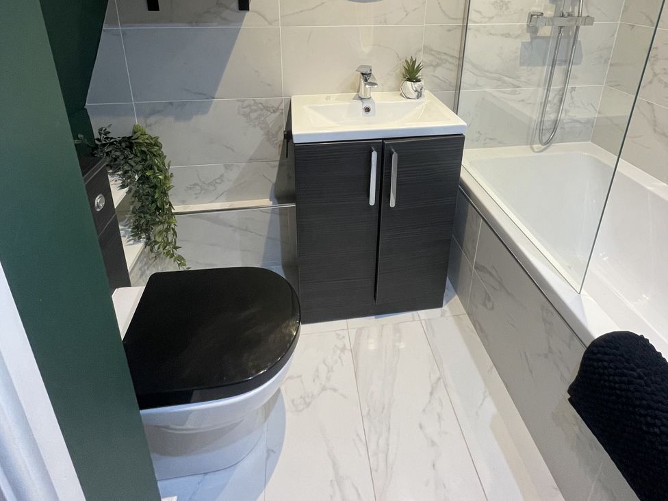 A bathroom with a sink, toilet, and bathtub at Old Chapel House Llanfairfechan