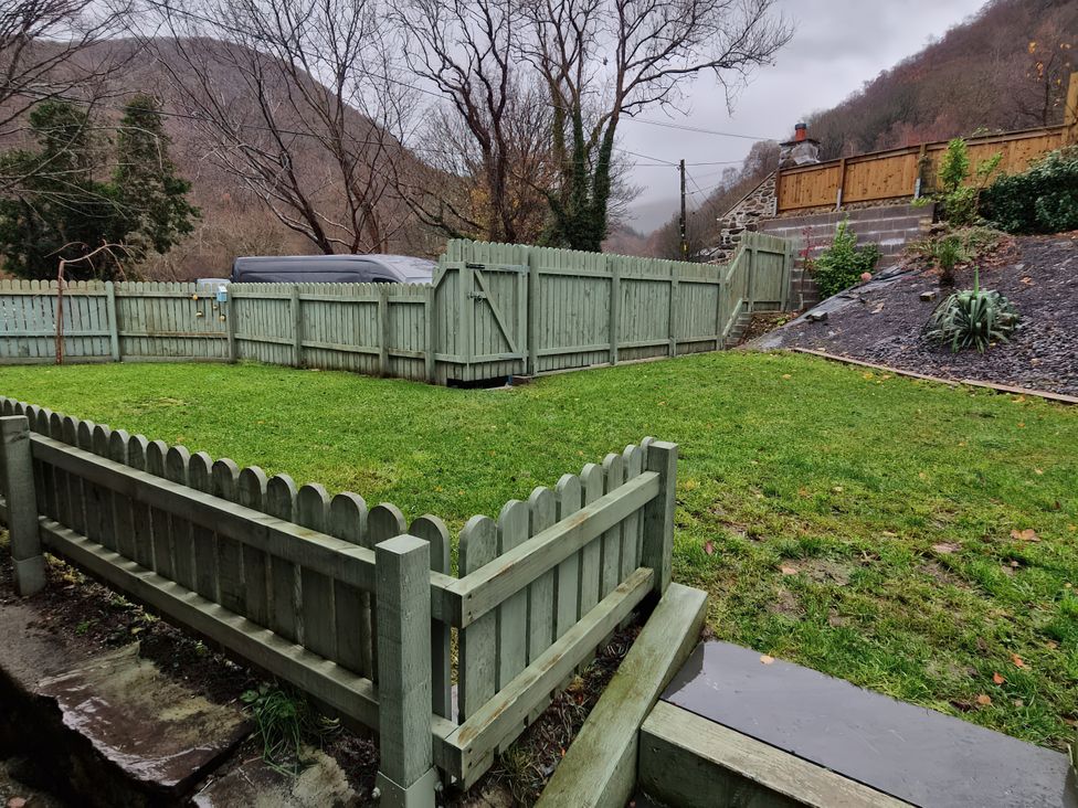 A garden with a fence and grass area at Old Chapel House Abergwyngregyn near Llanfairfechan