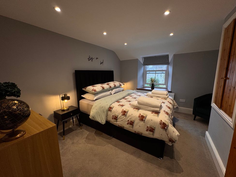 A bedroom with a bed and nightstand at Old Chapel House in Abergwyngregyn near Llanfairfechan
