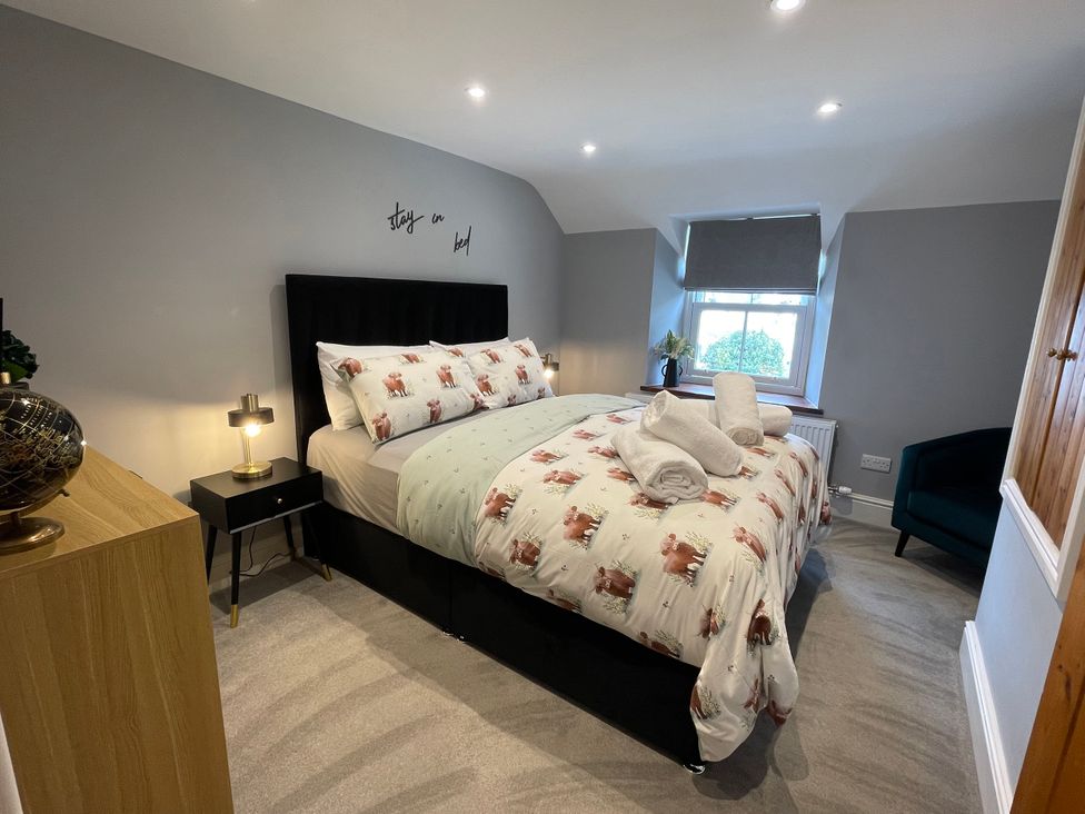 A bedroom with a large bed and bedside table at Old Chapel House Abergwyngregyn near Llanfairfechan