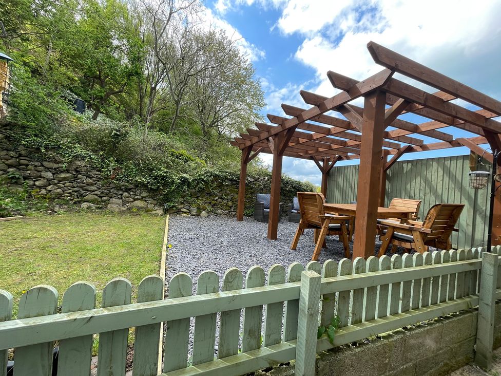 A garden with a pergola and seating area at Old Chapel House Abergwyngregyn near Llanfairfechan