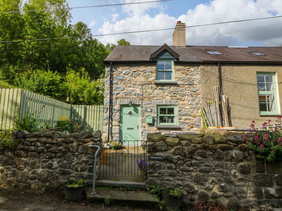 A house with a stone facade and green gate at Old Chapel House in Abergwyngregyn near Llanfairfechan
