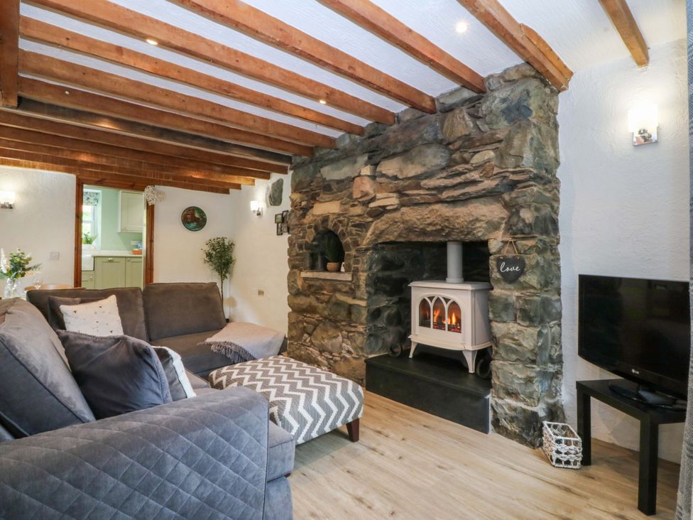 A living room with a fireplace and sofa at Old Chapel House Abergwyngregyn near Llanfairfechan