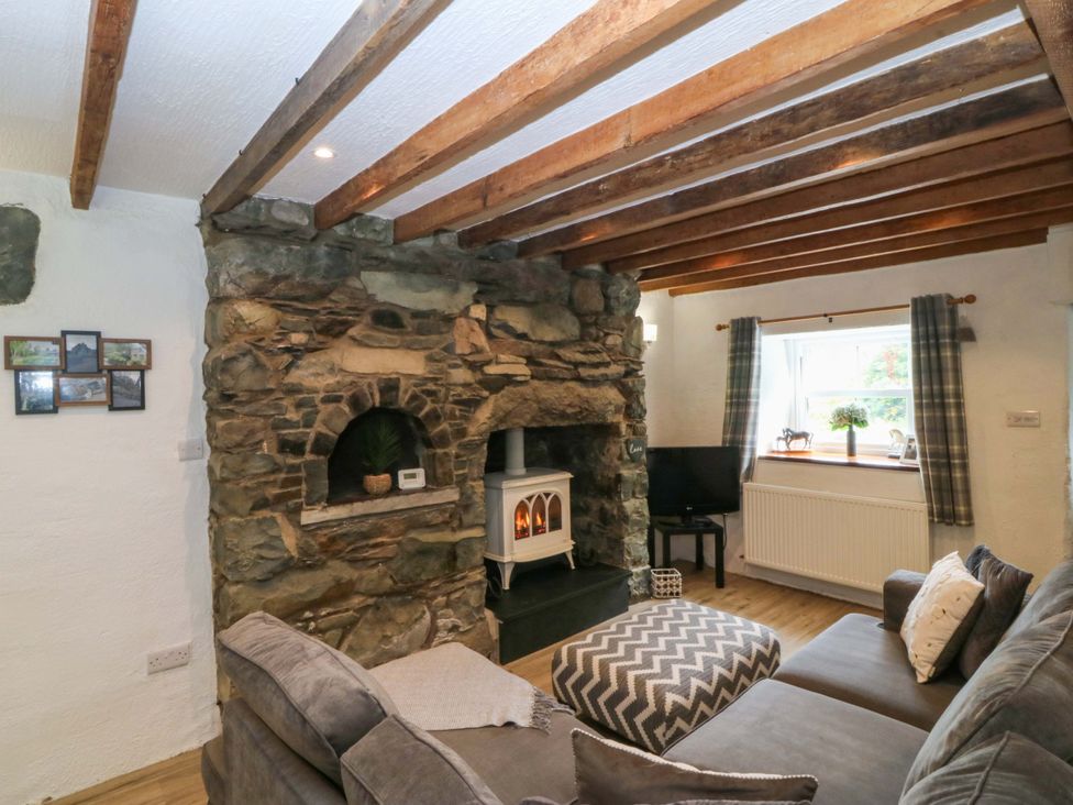 A living room with a fireplace and sofa at Old Chapel House Abergwyngregyn near Llanfairfechan