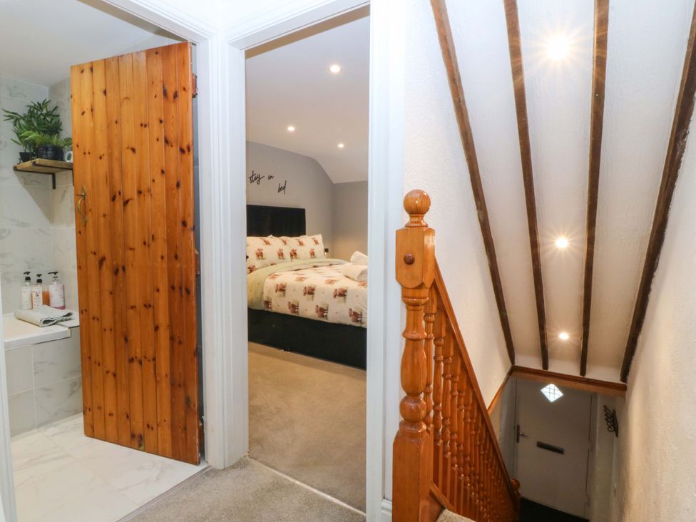 A hallway with a staircase and a door leading to a bedroom at Old Chapel House Abergwyngregyn near Llanfairfechan