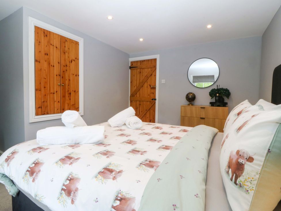 A bedroom with a double bed and wooden furniture at Old Chapel House Abergwyngregyn near Llanfairfechan