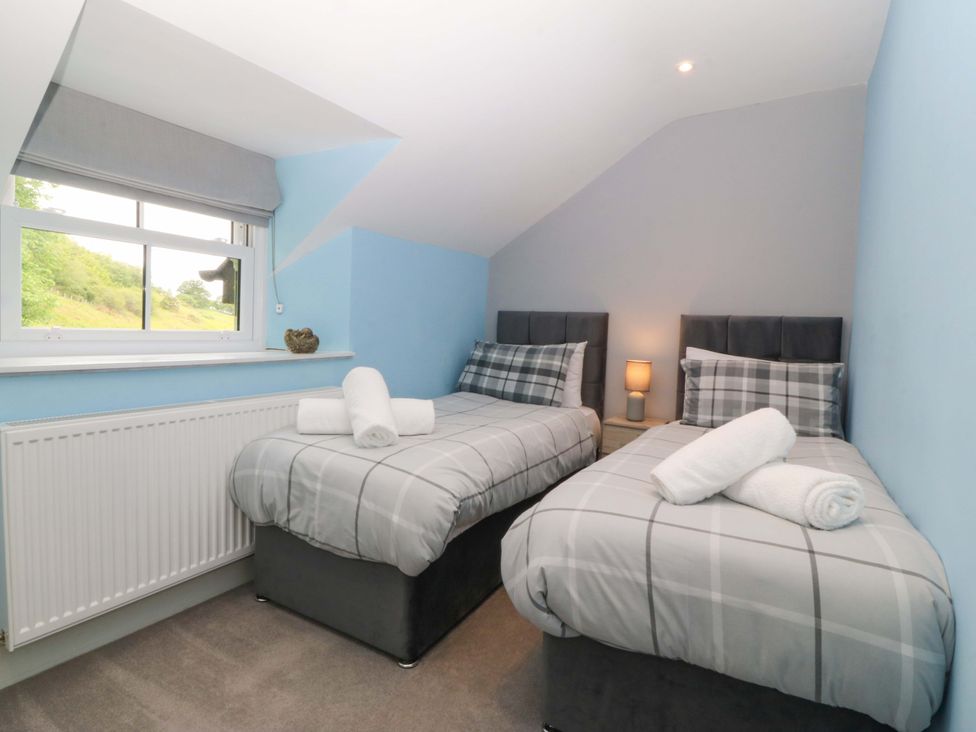 A bedroom with two twin beds and a window at Old Chapel House Abergwyngregyn near Llanfairfechan